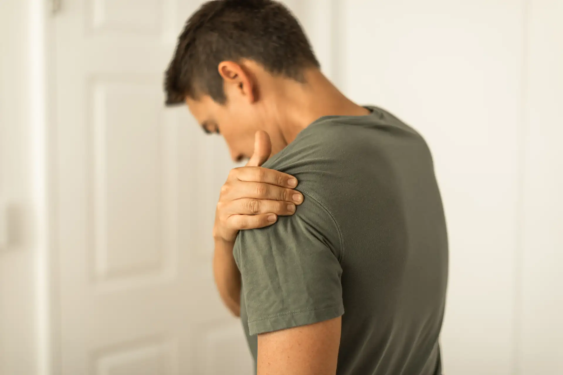 man holding his dislocated shoulder