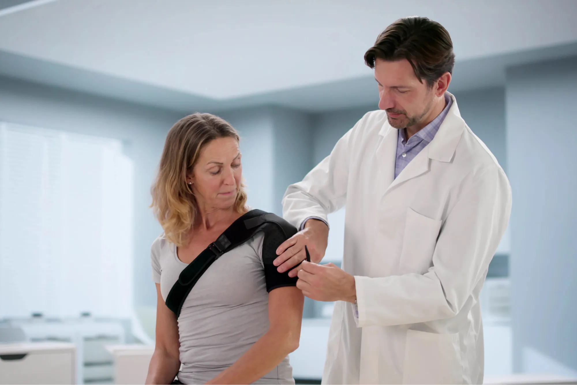 shoulder surgeon assisting patient