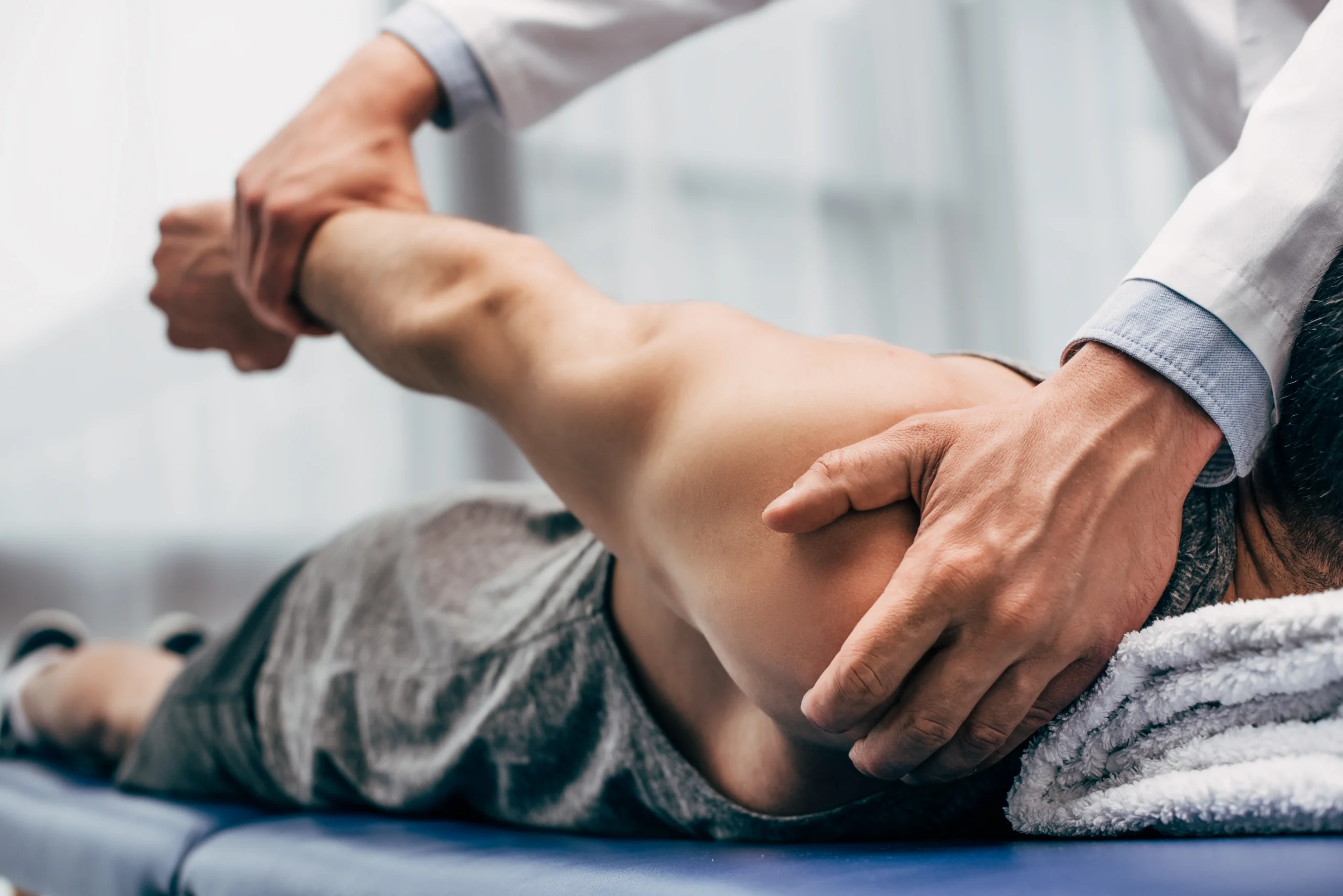 Orthopedic doctor checking someone's shoulder.