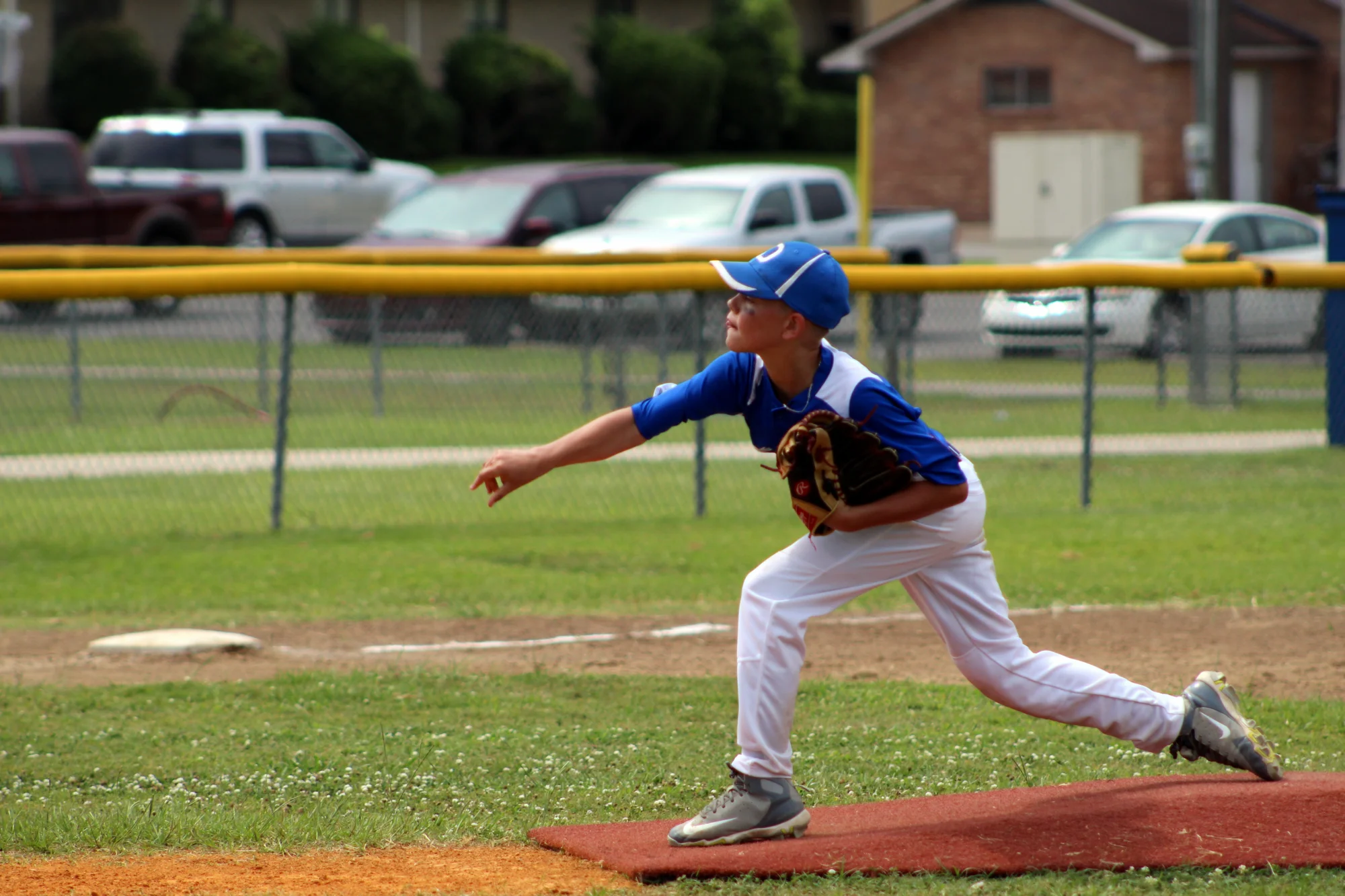 Younger kid pitching a baseball.